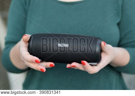 Young Girl Holds Nomi Black Portable Usb Speaker By Nomi Electronics Company. New Outstanding Mobile