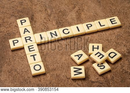 Pareto principle crossword in ivory letters against textured handmade bark paper, business, productivity, resource allocation and priorities concept