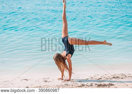Adorable Active Little Girl At Beach During Summer Vacation