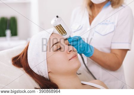 Close Up Of A Cheerful Young Woman Smiling Joyfully, Getting Endospheres Facial Treatment By Beautic