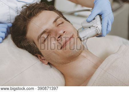 Attractive Relaxed Mature Man Getting Non-surgical Face Lift. Professional Cosmetologist Using Ultra