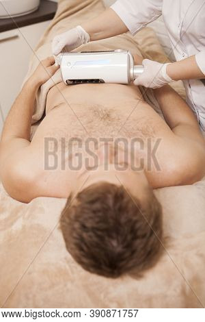 Vertical Shot Of A Male Client Getting Belly Massage By Therapist Using Endospheres Massage Apparatu