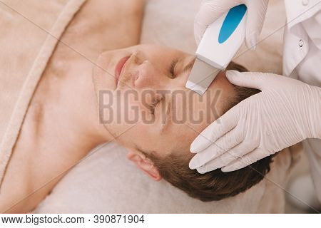Professional Cosmetitian Cleaning Skin Of Male Client With Ultrasound Cleansing Device