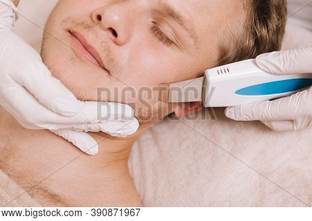 Cropped Close Up Of A Handsome Young Man Relaxing While Dermatologist Using Ultrasound Cleansing Dev