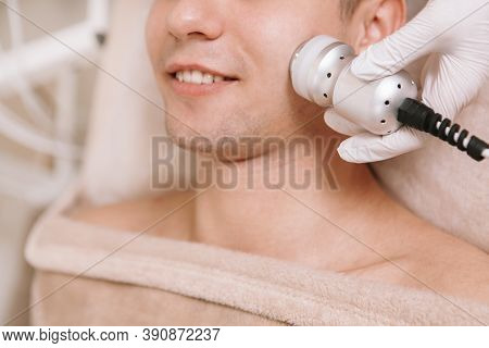 Cropped Shot Of A Young Man Smiling While Professional Beautician Using Cavitation Apparatus