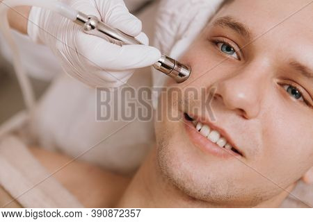 Cropped Close Up Of A Young Cheerful Man Smiling While Cosmetologist Performing Facial Skincare Trea