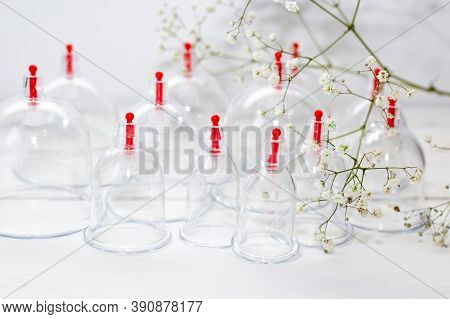 Jars For Hijama On A White Wooden Background And White Flowers. Bloodletting. Sunnah Treatment. Isla