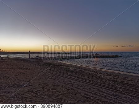 View Of The Sea And Stones On The Pedregalejo Beach At Dusk.