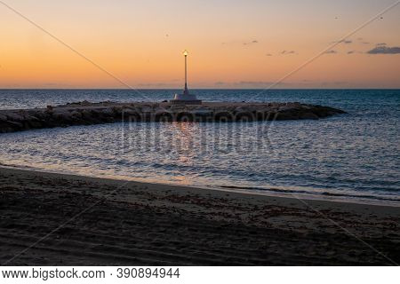 view of the sea and stones on the Pedregalejo Beach at dusk.