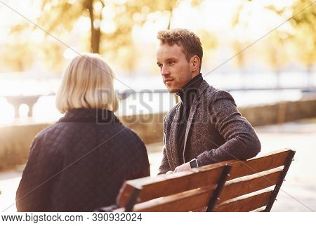 Grandmother With Young Guy In Formal Clothes Have Conversation In An Autumn Park.