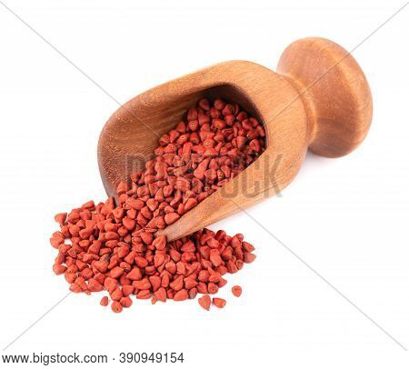 Annatto Seeds In Wooden Scoop, Isolated On White Background. Achiote Seeds, Bixa Orellana. Natural D