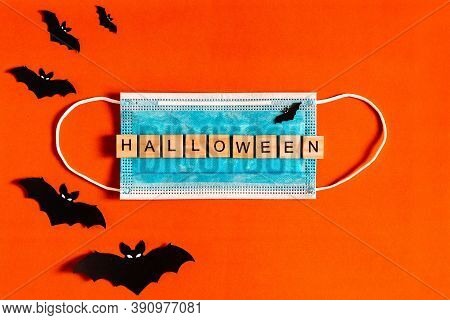 Lettering Halloween On A Medical Protective Mask On A Black Background With Silhouettes Of Bats Made