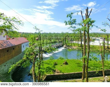 View On Waterfall, Mill In White Building, Pedestrian Bridge In Park Postojna Jama Near Postojna Cav