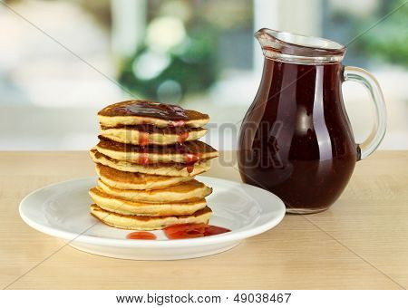 หวาน pancakes บนแผ่นกับแยมบนโต๊ะในห้องครัว