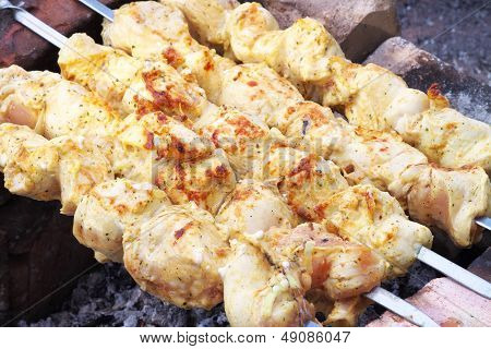 Ražniči na improvizované pece z cihel. Barbecue gril maso v procesu vaření.