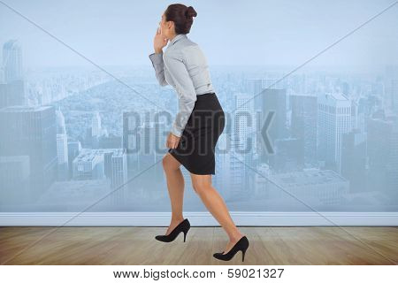 Businesswoman shouting against city scene in a room