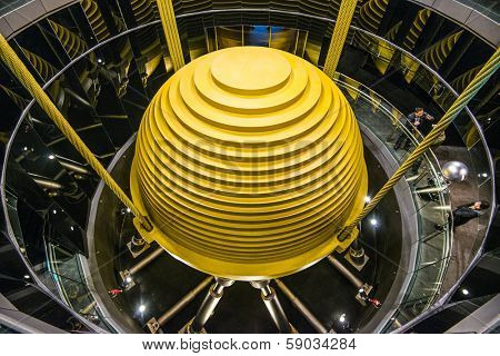 TAIPEI, TAIWAN - JANUARY 15, 2013: Tourists observe the world's largest tuned mass damper in Taipei 101. The device is used to reduce unwanted vibration from wind and earthquakes.