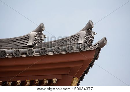 Detail On Japanese Temple Roof Against Blue Sky.