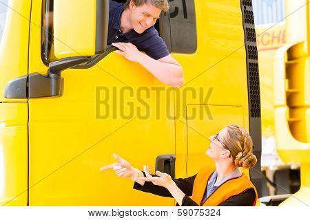 Logistics - proud driver or forwarder in drivers cap of truck and trailer, on a transshipment point