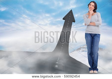 Young woman in thinkers pose against road turning into arrow