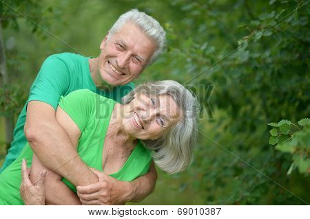Senior man hugging senior woman in forest