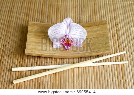 Orchids on bamboo mat abstract asian food concept