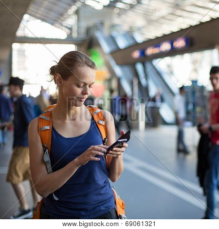Pretty, young woman in a trainstation, waiting for her train, boarding a train (color toned image)