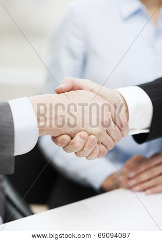 businesss and office concept - two businessmen shaking hands in office
