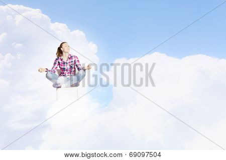Young woman sitting on chair and meditating