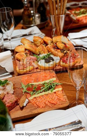 Italian appetizers on wooden plank, arranged table