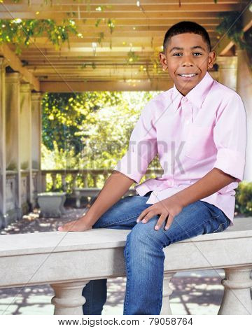 A handsome young boy happily straddling a balustrade.