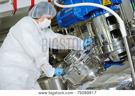 pharmaceutical worker with equipment mixing tank on production line in pharmacy industry manufacture factory