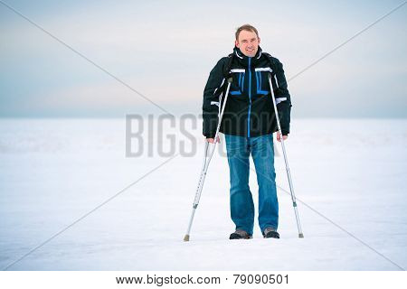 Man with crutches walking outdoors