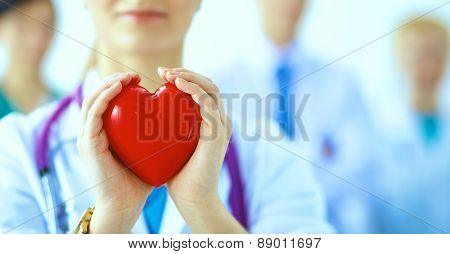 Female doctor with stethoscope holding heart .