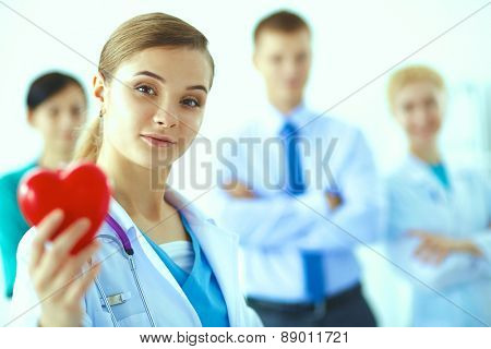 Female doctor with stethoscope holding heart .