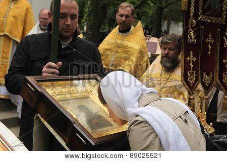 PRAGUE, CZECH REPUBLIC - MAY 28, 2012: Orthodox believer kisses the miracle-working icon of the Virgin Mary in front of the Dormition Church at the Olsany Cemetery in Prague, Czech Republic.