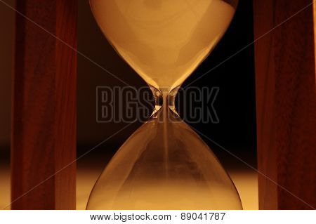 Sand pours in hourglass