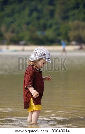 Child Walking On Fine Sand Through The Water