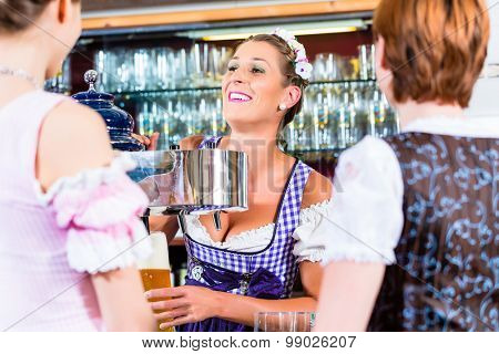 Innkeeper in Bavarian pub with customers