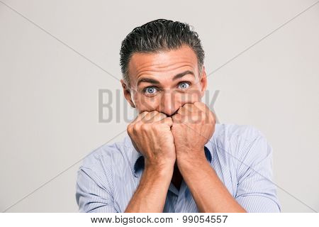 Portrait of a scared young man standing isolated on a white background