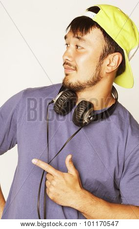 young asian man in hat and headphones listening music on white background