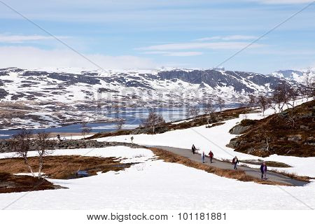 HARDANGERVIDDA, NORWAY - JUN 11 2015 : Visitors file back from the Sysen Dam and the Reservoir.
