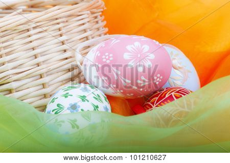 Close-up of strawy basket with Easter eggs and velvet