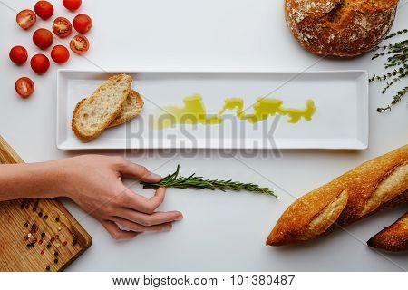 Composition With Bread, Olive Oil, Tomatoes Cherry, Pepper And Hand Holding Rosemary