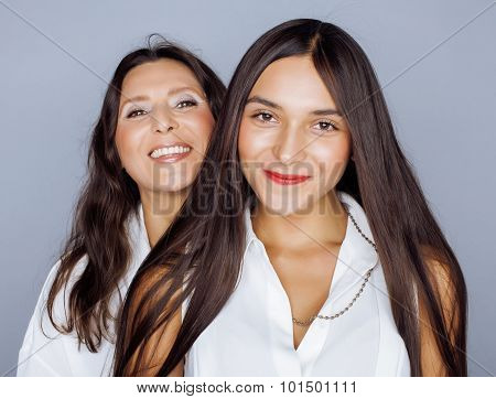 cute pretty teen daughter with mature mother hugging, fashion style brunette makeup