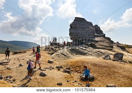 Unidentified group of bikers climbs the hill in Bucegi Mountains