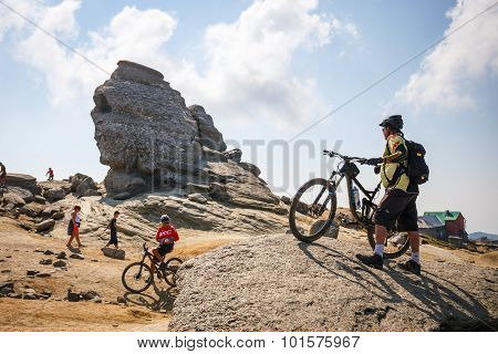 Unidentified group of bikers climbs the hill in Bucegi Mountains