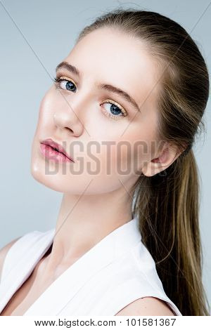 Beauty fashion girl. Portrait of beautiful young woman with fresh clean skin on grey background