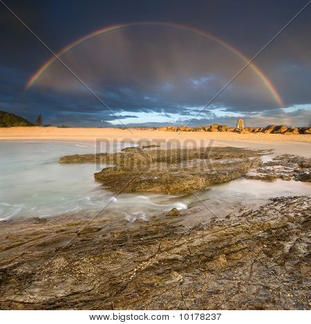 arco iris con roca en primer plano en la mañana nublada