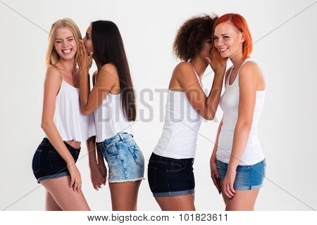 Portrait of a four girls gossiping isolated on a white background